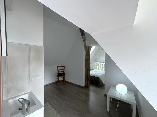 La salle de bains est pourvue de murs blancs, d'un lavabo et d'un lit. dans l'établissement Au charme Amboisien, maison centre ville avec jardin, à Amboise