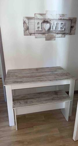 un banc blanc assis devant un mur dans l'établissement La Halte de Massiac 1er étage, à Massiac