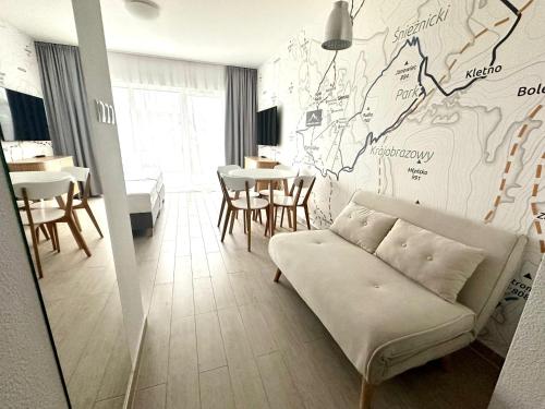 ein Wohnzimmer mit einem Sofa und einer Karte an der Wand in der Unterkunft Apartament Czarna Góra Resort - Livigno in Heudorf