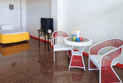 a room with a table and chairs and a table and a tv at MBU Suites Bed n Breakfast RedPartner in Guiguilonen