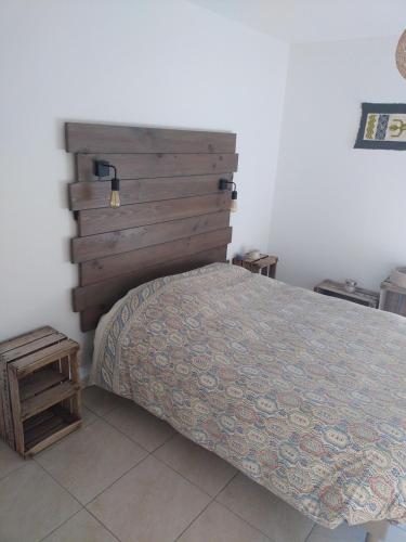 une chambre avec un lit et une tête de lit en bois dans l'établissement Appartement proche de la mer, à Banyuls-sur-Mer