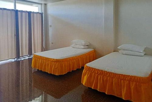 two beds sitting in a room with a window at MBU Suites Bed n Breakfast RedPartner in Guiguilonen