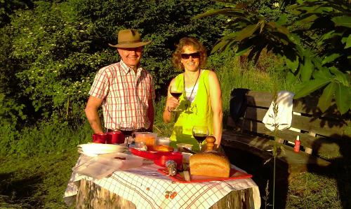 un hombre y una mujer de pie junto a una mesa de picnic en B&B Sunnesite Pratteln, en Pratteln