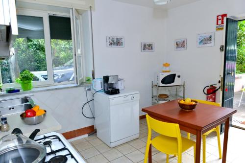 a kitchen with a table and yellow chairs and a table and a kitchen with at I giardini di Daphne in Meta