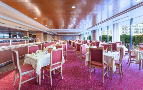 une salle à manger avec des tables et des chaises dans un restaurant dans l'établissement El Mouradi Hotel Africa Tunis, à Tunis