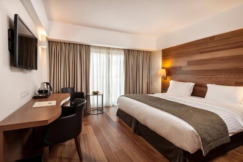 a hotel room with a bed and a desk at Samaria Hotel in Chania Town