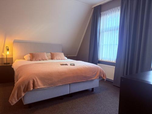 a bedroom with a large bed and a window at Hotel Restaurant 't Ronde Loegh in Winschoten