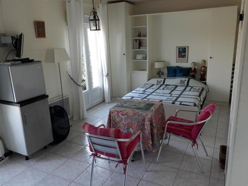 une chambre avec un lit, une table et des chaises dans l'établissement Studio meublé 2 pièces jardin piscine, à Soulac-sur-Mer