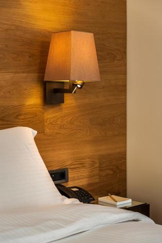 a bedroom with a bed with a lamp and a telephone at Samaria Hotel in Chania Town
