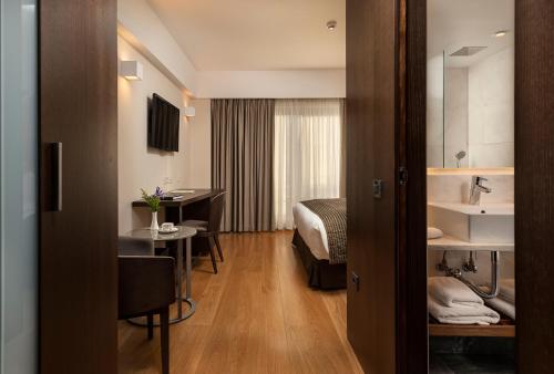 a hotel room with a bed and a sink and a table at Samaria Hotel in Chania Town