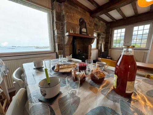 une cuisine avec une table et une bouteille de sauce dans l'établissement Charmante maison bretonne proche de la mer, à Porspoder