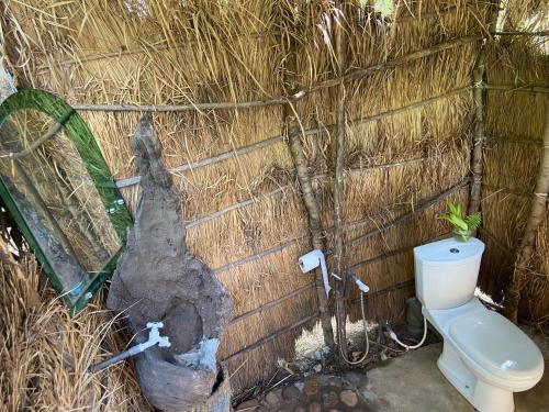 a small bathroom with a toilet and a large log at Moonshade Handapanagala in Monaragala