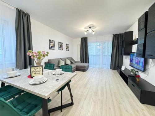 a living room with a table and a couch at Luxury Glam Apartments Coresi Mall Area in Braşov