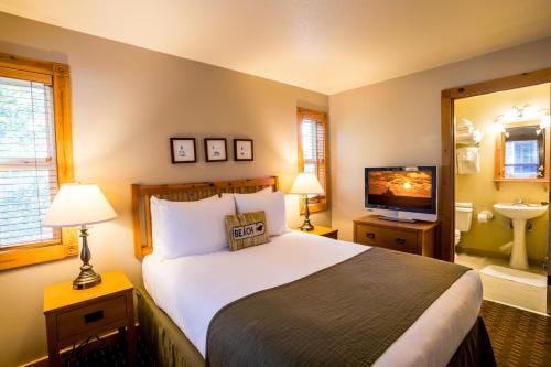 a bedroom with a large bed and a television at Lighthouse Inn in Cannon Beach