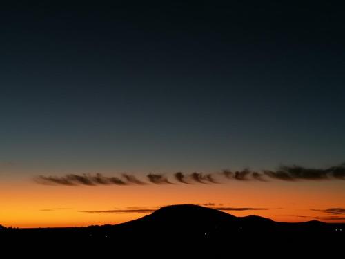 a sunset with a silhouette of a mountain at Terra Cristal - Ágata in Piriápolis