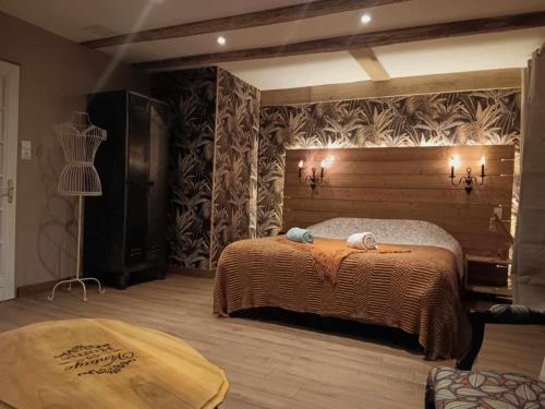 - une chambre avec un lit et un mur orné de plantes dans l'établissement Ferme des molieres avec espace détente, à Mortagne