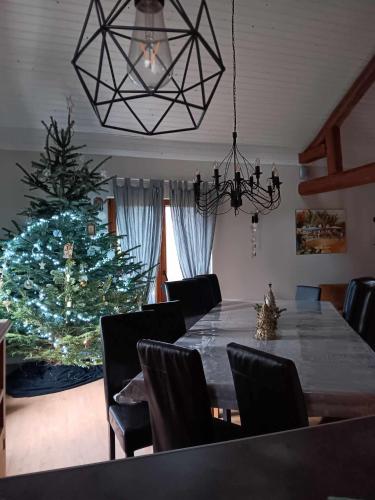 une salle à manger avec une table et un sapin de Noël dans l'établissement Ferme des molieres avec espace détente, à Mortagne