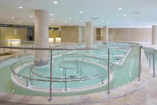 une piscine d'eau avec un escalier en colimaçon dans un bâtiment dans l'établissement Appartement T2 - Cosy 400m des thermes, à Cazaubon