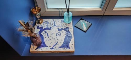 a wooden cutting board with a painting on a blue wall at Chapelle Notre Dame du Rail in Jarny