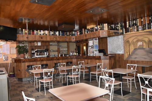 un restaurant avec des tables et des chaises et un bar dans l'établissement Hôtel Le Rider, à Bort-les-Orgues