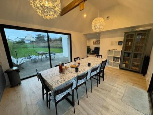 une grande salle à manger avec une table et des chaises dans l'établissement Jolie maison contemporaine proche plage, à Ploudalmézeau