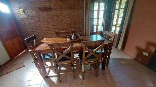 a wooden table and chairs in a room at Cabañas CALIGÜE in Malargüe