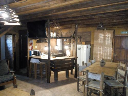 a kitchen and dining room with a table and a refrigerator at Cabañas CALIGÜE in Malargüe