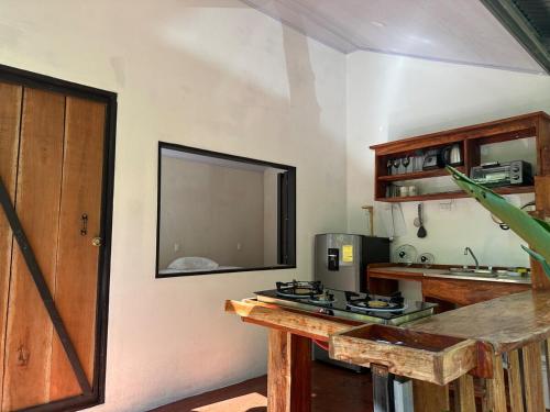 a kitchen with a counter and a stove top oven at Cabañas Playa Cedros in Puntarenas