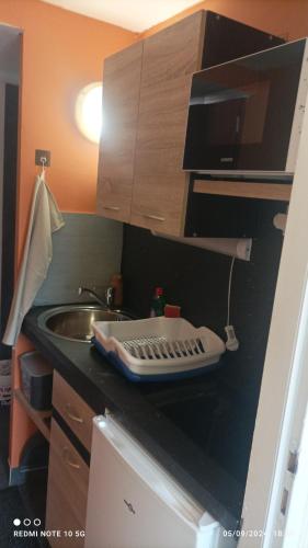 - un comptoir de cuisine avec un évier et une planche de coupe dans l'établissement Lolft 3 PROCHE FUTUROSCOPE, à Fontaine-le-Comte