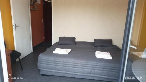 une chambre avec un lit avec deux oreillers dessus dans l'établissement Lolft 3 PROCHE FUTUROSCOPE, à Fontaine-le-Comte