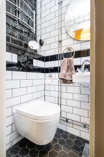 a white bathroom with a toilet and a sink at Modern & Bright Central Helsinki in Helsinki