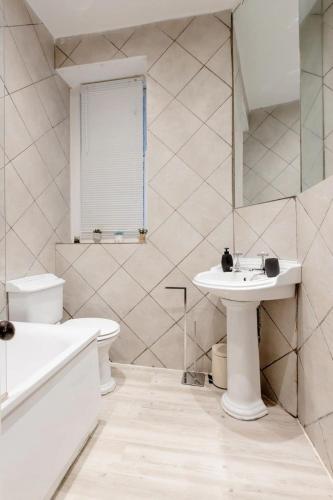 a white bathroom with a sink and a toilet at Cozy flat Near Paddington in London