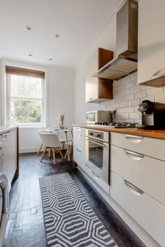 a kitchen with white appliances and a dining room at Cozy flat Near Paddington in London