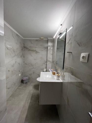 Un baño blanco con lavabo y espejo. en Jimilio 1, en Spáta