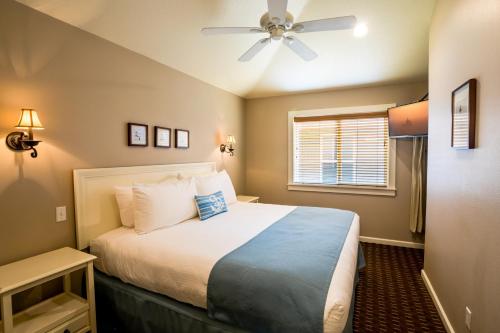a bedroom with a bed and a ceiling fan at Lighthouse Inn in Cannon Beach