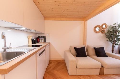 une cuisine avec un évier et un canapé dans une chambre dans l'établissement Le Royal - Lyon 1er - Studio Mezzanine Croix Paquet, à Lyon