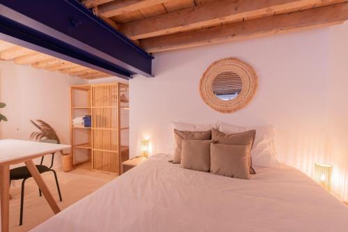 une chambre avec un lit blanc et une table dans l'établissement Le Royal - Lyon 1er - Studio Mezzanine Croix Paquet, à Lyon