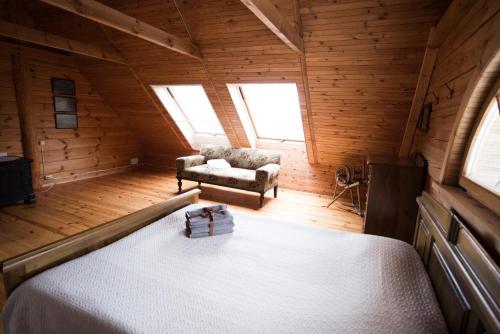 una camera da letto con un letto e una sedia in una stanza di Pakaso sodyba, šiaurinė pusė a Kirdeikiai