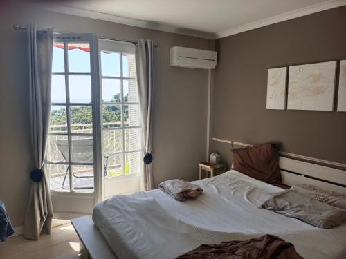 une chambre avec un lit et une grande fenêtre dans l'établissement Appartement 110 m2 vue mer environnement exceptionnel, à Hyères