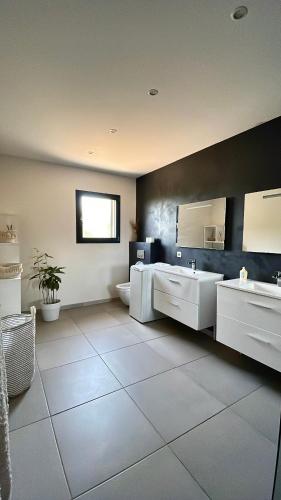 - une grande salle de bains avec deux lavabos et un miroir dans l'établissement CasaNota Haut de villa 200m2 avec piscine privée, à Porto-Vecchio