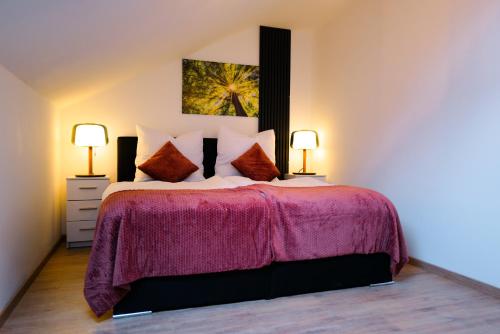 エルディングにあるCozy Apartment near Therme Erdingのベッドルーム1室(紫の毛布とランプ2つ付)