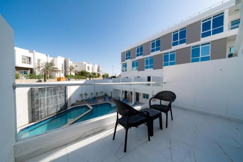 a balcony with two chairs and a swimming pool on a building at Sky Star Hotel free shuttle to Hurghada City center in Hurghada