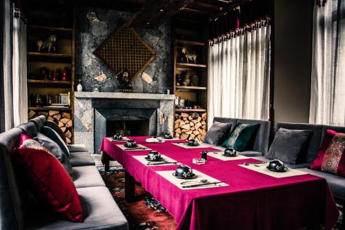 a dining room with a table and a fireplace at Arro Khampa By Zinc Journey Shangri-la in Shangri-La