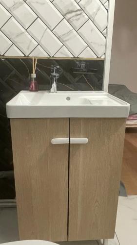 La salle de bains est pourvue d'un lavabo et d'un miroir. dans l'établissement Maison type appartement 1ère étage, à Lieusaint