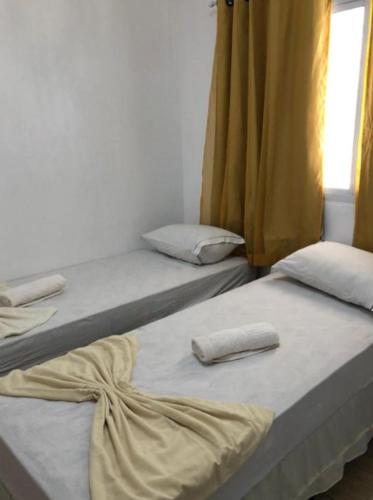 two beds sitting next to each other in a room at Pousada MC in Aparecida