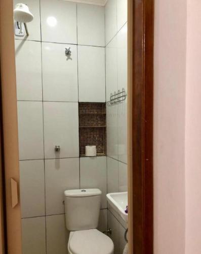 a small bathroom with a toilet and a sink at Pousada MC in Aparecida