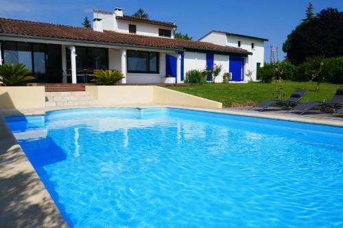 une grande piscine bleue devant une maison dans l'établissement Villa du tertre, à Fronsac