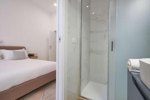 un bagno con doccia in vetro e un letto di Dolce Vita Guest House a Torre del Greco