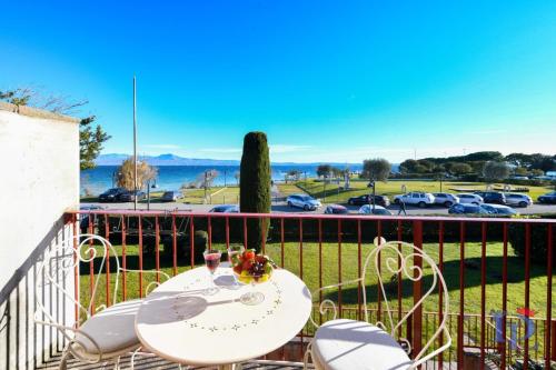 a table and chairs on a balcony with a view of a parking lot at DesenzanoLoft Official Partner Homes & Villas by Marriott Bonvoy - Eden Lake view and privat beach renovated in 2025 in Sirmione