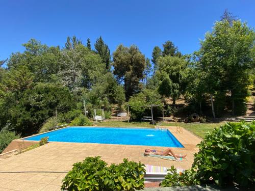 a swimming pool with two people laying on the side at Casa amplia con piscina y quincho in Concepción